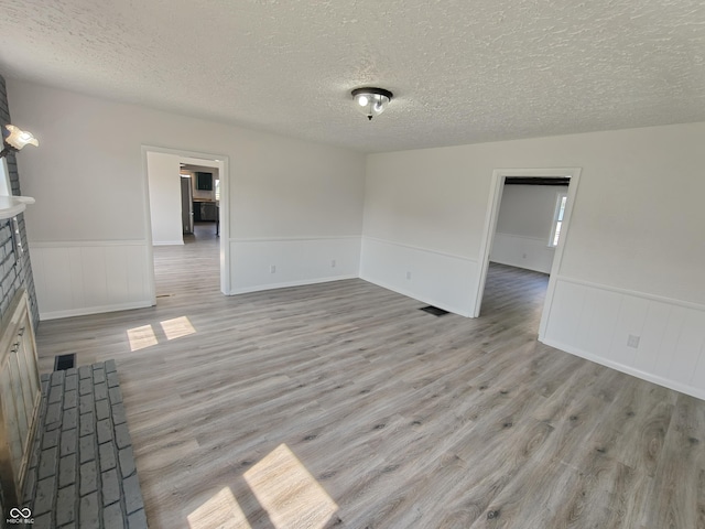 316 E Mechanic St, Shelbyville, IN 46176 - spare room featuring a textured ceiling, wainscoting, and light wood-type flooring
