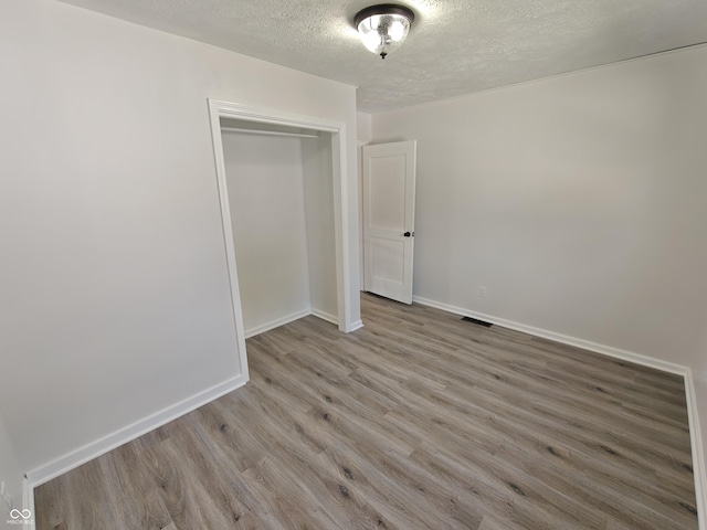 316 E Mechanic St, Shelbyville, IN 46176 - unfurnished bedroom featuring a textured ceiling, wood finished floors, and a closet