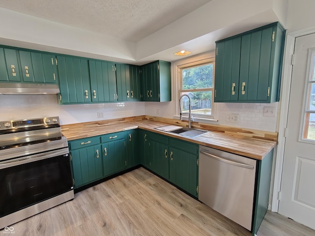 316 E Mechanic St, Shelbyville, IN 46176 - kitchen with stainless steel appliances, under cabinet range hood, light wood finished floors, a textured ceiling, and butcher block countertops