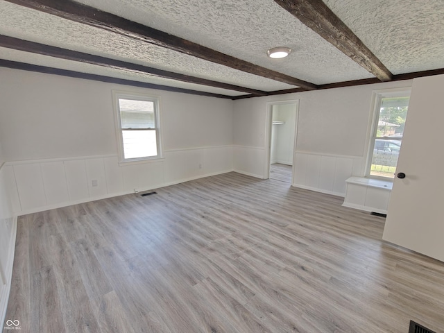 316 E Mechanic St, Shelbyville, IN 46176 - unfurnished room with beam ceiling, wainscoting, light wood-style flooring, and a textured ceiling