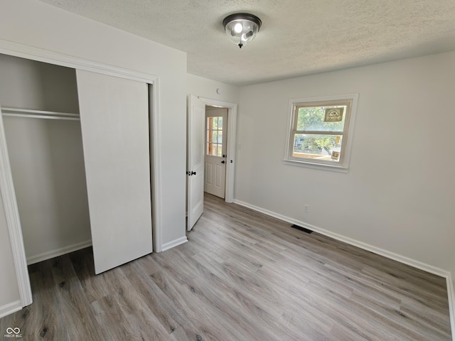 316 E Mechanic St, Shelbyville, IN 46176 - unfurnished bedroom with a textured ceiling, wood finished floors, and a closet