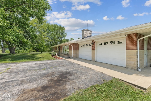 10816 N US Highway 231, Cloverdale, IN 46120 - view of side of home with brick siding, a chimney, a yard, and an attached garage