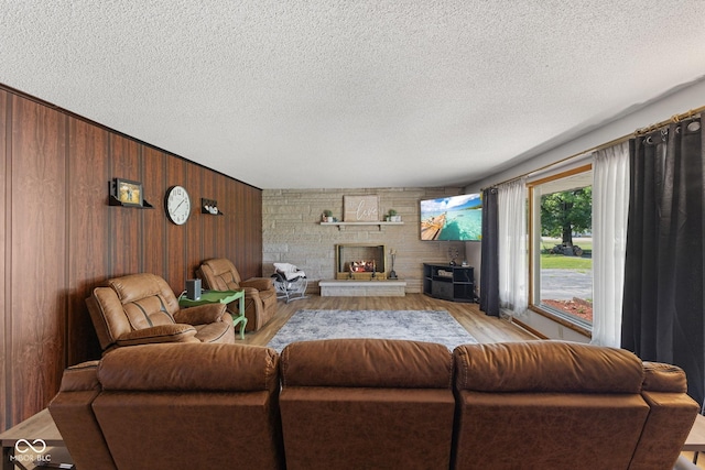 10816 N US Highway 231, Cloverdale, IN 46120 - living area with light wood-style flooring, wood walls, a textured ceiling, and a fireplace
