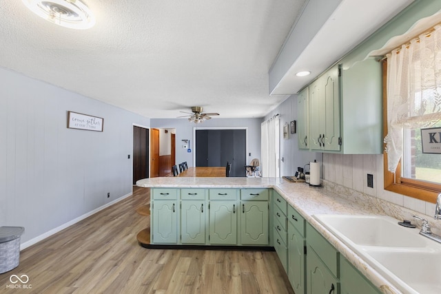 10816 N US Highway 231, Cloverdale, IN 46120 - kitchen with a peninsula, light countertops, light wood-type flooring, a ceiling fan, and green cabinets