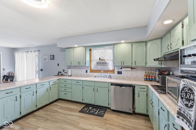 10816 N US Highway 231, Cloverdale, IN 46120 - kitchen with appliances with stainless steel finishes, a textured ceiling, healthy amount of natural light, light wood-style floors, and under cabinet range hood