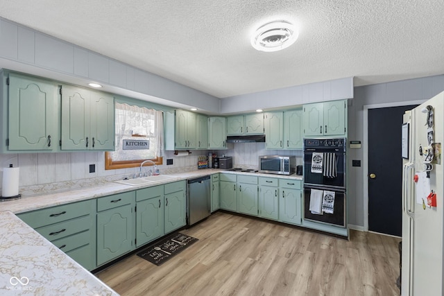 10816 N US Highway 231, Cloverdale, IN 46120 - kitchen with appliances with stainless steel finishes, light wood-style floors, a textured ceiling, light countertops, and under cabinet range hood