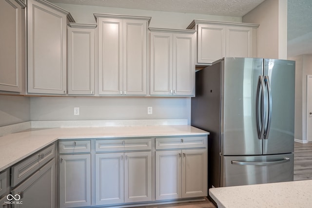2541 Riviera Pl, Greenwood, IN 46143 - kitchen featuring freestanding refrigerator, gray cabinets, wood finished floors, and light stone counters