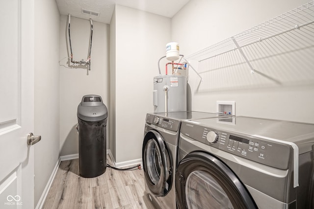 2541 Riviera Pl, Greenwood, IN 46143 - laundry area with water heater, washing machine and clothes dryer, and light wood-style flooring