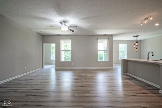 2541 Riviera Pl, Greenwood, IN 46143 - unfurnished living room with ceiling fan, dark wood-type flooring, and a textured ceiling