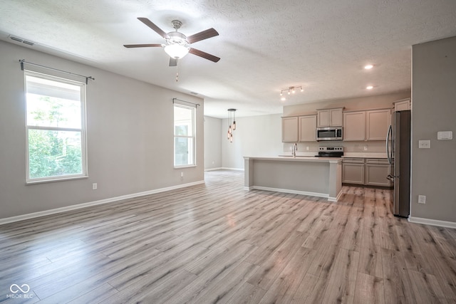 2541 Riviera Pl, Greenwood, IN 46143 - kitchen featuring stainless steel appliances, open floor plan, ceiling fan, light wood-style floors, and a center island with sink