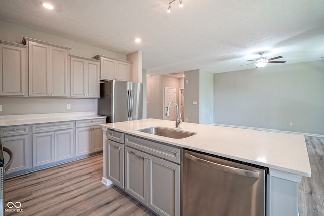 2541 Riviera Pl, Greenwood, IN 46143 - kitchen with stainless steel appliances, gray cabinetry, light wood finished floors, a kitchen island with sink, and a ceiling fan