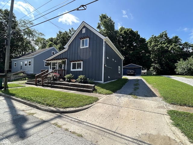 315 W N St, Crawfordsville, IN 47933 - view of front of house with board and batten siding, gravel driveway, an outdoor structure, and a front lawn
