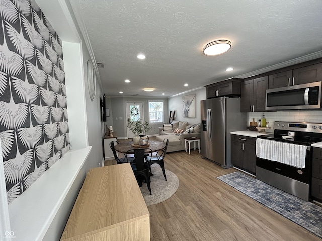 315 W N St, Crawfordsville, IN 47933 - kitchen with stainless steel appliances, light wood-style flooring, crown molding, light countertops, and open floor plan