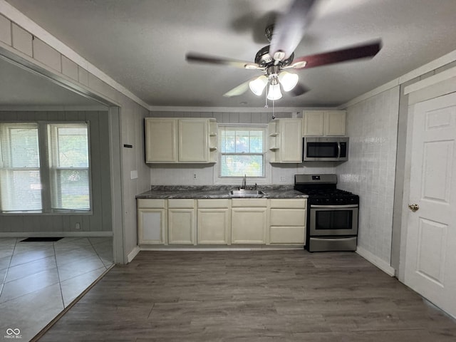 2002 N Audubon Rd, Indianapolis, IN 46218 - kitchen with stainless steel appliances, dark countertops, crown molding, ceiling fan, and open shelves