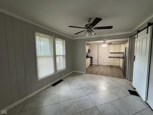 2002 N Audubon Rd, Indianapolis, IN 46218 - unfurnished living room with crown molding, a barn door, a ceiling fan, and light tile patterned floors