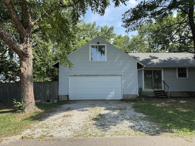 2002 N Audubon Rd, Indianapolis, IN 46218 - view of front of home with entry steps, gravel driveway, an attached garage, and a shingled roof