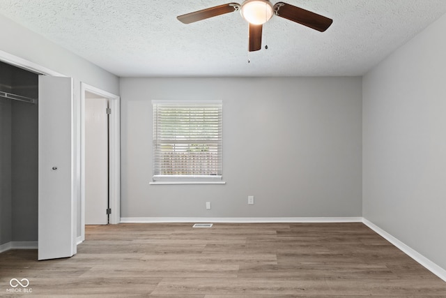 3102 Pawnee Dr, Indianapolis, IN 46235 - unfurnished bedroom featuring a textured ceiling, light wood-style flooring, a closet, and a ceiling fan