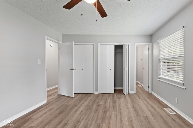 3102 Pawnee Dr, Indianapolis, IN 46235 - unfurnished bedroom with light wood finished floors, two closets, a textured ceiling, and ceiling fan