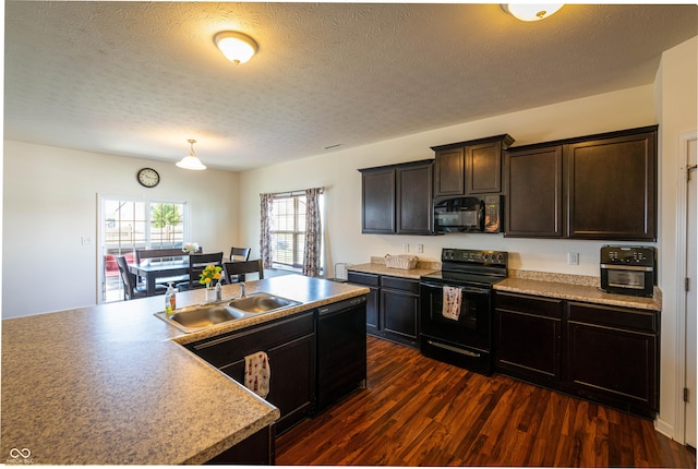 7626 Merrick Dr, Brownsburg, IN 46112 - kitchen featuring black appliances, dark wood-style floors, a textured ceiling, dark brown cabinetry, and light countertops