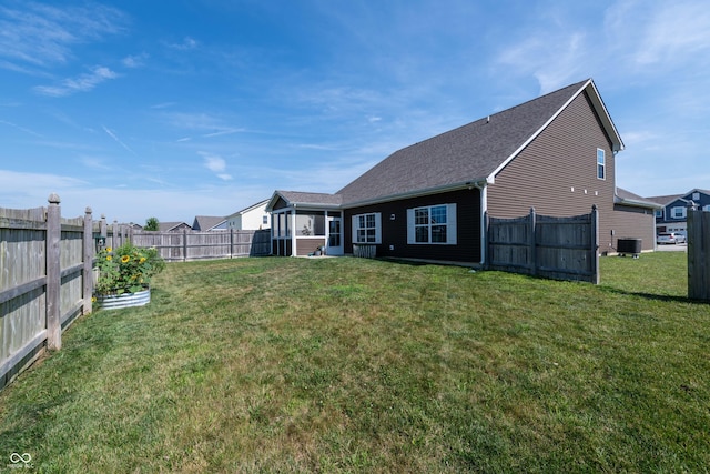 7626 Merrick Dr, Brownsburg, IN 46112 - back of house with a fenced backyard, roof with shingles, and a sunroom