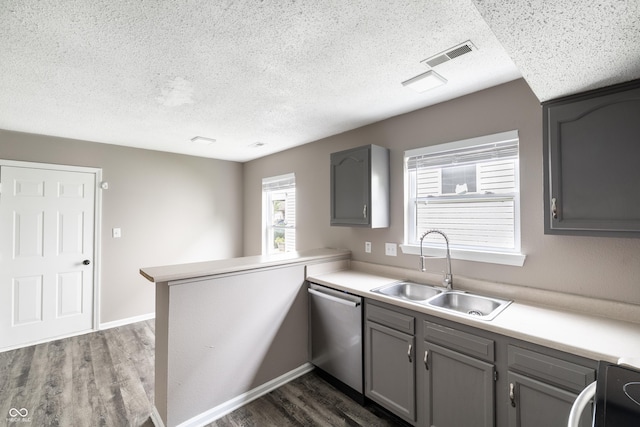 3307 Blue Ash, Indianapolis, IN 46239 - kitchen with a textured ceiling, stainless steel dishwasher, gray cabinetry, a peninsula, and dark wood-style floors