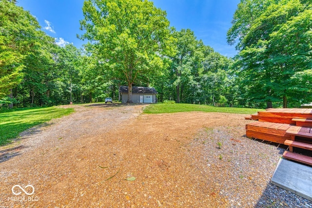 8910 Richarts Rd, Morgantown, IN 46160 - view of yard featuring a garage, a wooden deck, a shed, and a forest view
