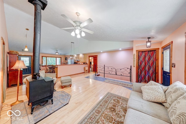 8910 Richarts Rd, Morgantown, IN 46160 - living area featuring a wood stove, a ceiling fan, vaulted ceiling, and light wood-style flooring