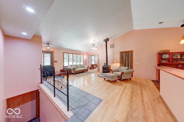 8910 Richarts Rd, Morgantown, IN 46160 - living room with a wood stove, lofted ceiling, light wood finished floors, a textured ceiling, and a ceiling fan