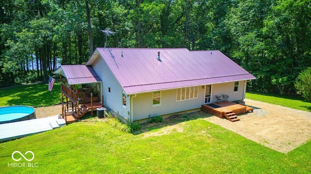 8910 Richarts Rd, Morgantown, IN 46160 - rear view of house with a lawn, a metal roof, an outdoor pool, a deck, and covered porch