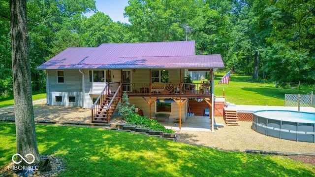 8910 Richarts Rd, Morgantown, IN 46160 - back of property with stairway, a lawn, a metal roof, an outdoor pool, and a wooden deck
