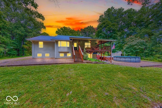 8910 Richarts Rd, Morgantown, IN 46160 - view of front of home with stairway, a front yard, a wooden deck, a metal roof, and an outdoor pool