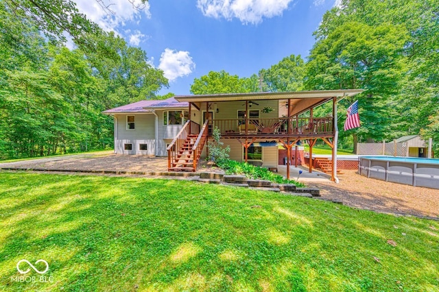 8910 Richarts Rd, Morgantown, IN 46160 - back of property with stairway, a lawn, a wooden deck, a ceiling fan, and an outdoor pool