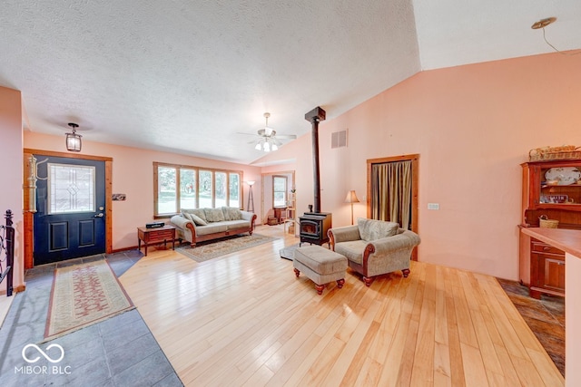 8910 Richarts Rd, Morgantown, IN 46160 - living area with a wood stove, vaulted ceiling, wood finished floors, ceiling fan, and a textured ceiling