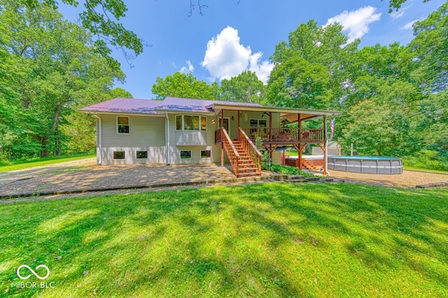 8910 Richarts Rd, Morgantown, IN 46160 - rear view of property featuring a lawn, stairway, a metal roof, an outdoor pool, and a patio area