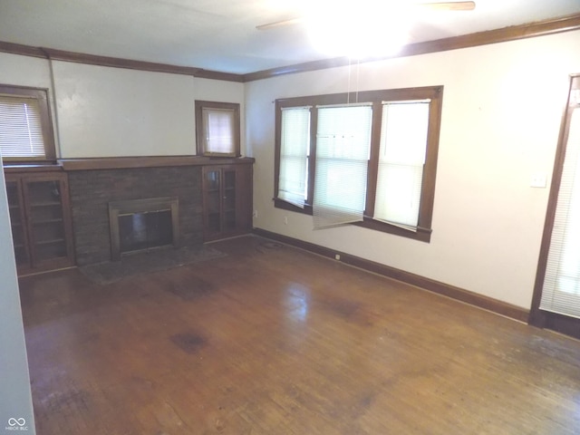 940 N Grant Ave, Indianapolis, IN 46201 - unfurnished living room with wood finished floors, a ceiling fan, ornamental molding, and a brick fireplace