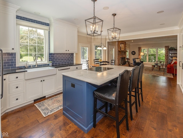 8708 Highwood Ln, Indianapolis, IN 46278 - kitchen with black electric cooktop, open floor plan, white cabinets, tasteful backsplash, and a kitchen island