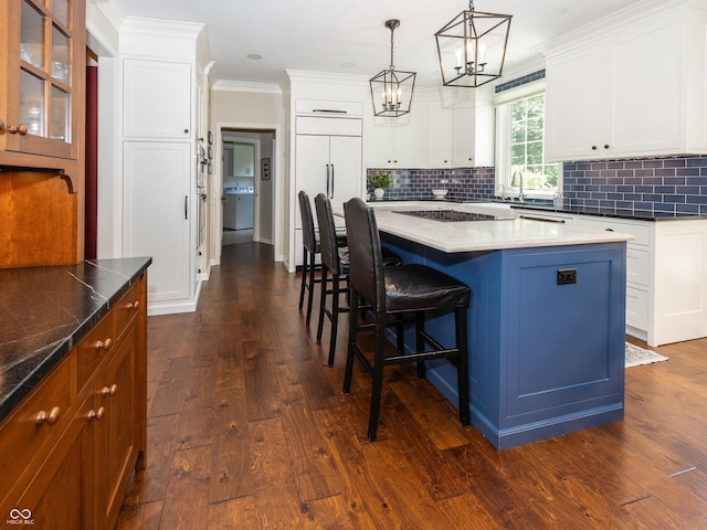 8708 Highwood Ln, Indianapolis, IN 46278 - kitchen featuring a kitchen breakfast bar, tasteful backsplash, a kitchen island, a chandelier, and crown molding