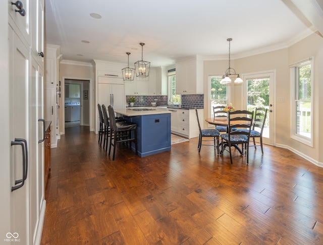8708 Highwood Ln, Indianapolis, IN 46278 - kitchen featuring backsplash, white cabinetry, a kitchen island, dark wood finished floors, and healthy amount of natural light