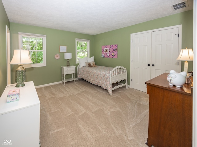 8708 Highwood Ln, Indianapolis, IN 46278 - bedroom featuring multiple windows, light colored carpet, a closet, and a textured ceiling