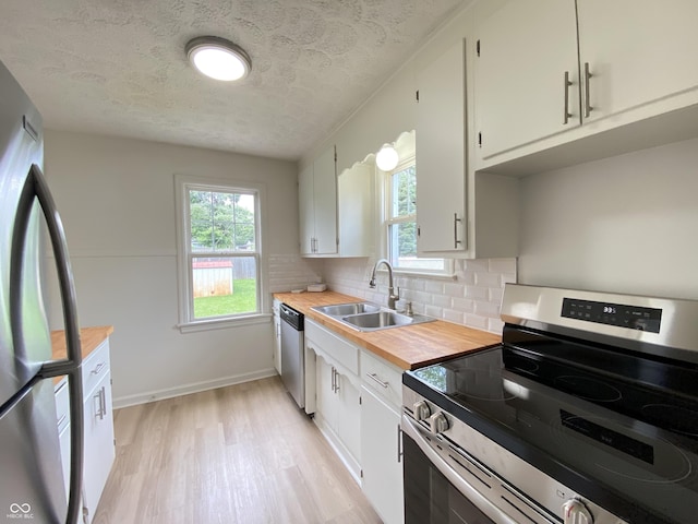4002 E Pleasant Run Parkway N Drive, Indianapolis, IN 46201 - kitchen with stainless steel appliances, wooden counters, a textured ceiling, light wood-type flooring, and backsplash