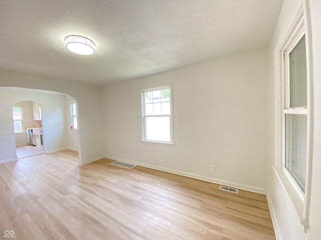 4002 E Pleasant Run Parkway N Drive, Indianapolis, IN 46201 - unfurnished room featuring arched walkways, light wood-type flooring, and a textured ceiling