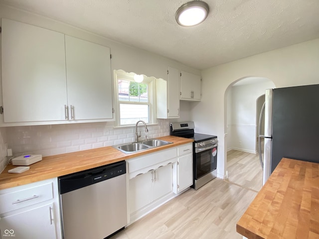 4002 E Pleasant Run Parkway N Drive, Indianapolis, IN 46201 - kitchen featuring wooden counters, appliances with stainless steel finishes, arched walkways, tasteful backsplash, and light wood-style floors