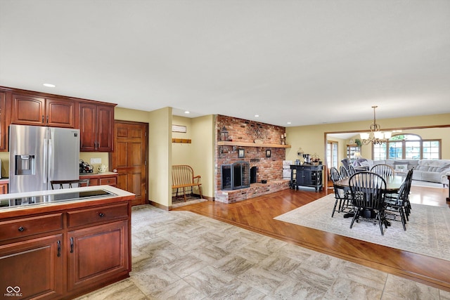 5238 N 225 E, Whiteland, IN 46184 - kitchen with stainless steel fridge with ice dispenser, open floor plan, black electric cooktop, a brick fireplace, and a chandelier