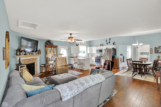 5238 N 225 E, Whiteland, IN 46184 - living room with a fireplace with flush hearth, dark wood-style floors, a chandelier, a ceiling fan, and attic access