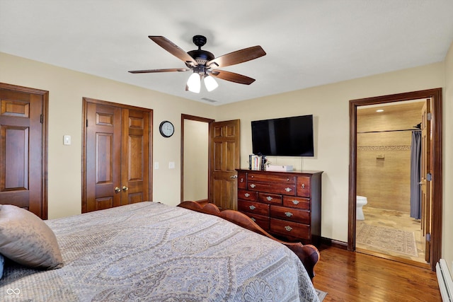 5238 N 225 E, Whiteland, IN 46184 - bedroom with baseboard heating, wood finished floors, a closet, ceiling fan, and ensuite bathroom