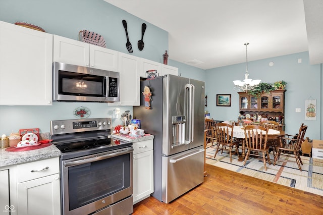 5238 N 225 E, Whiteland, IN 46184 - kitchen with appliances with stainless steel finishes, a chandelier, light countertops, and light wood-style floors