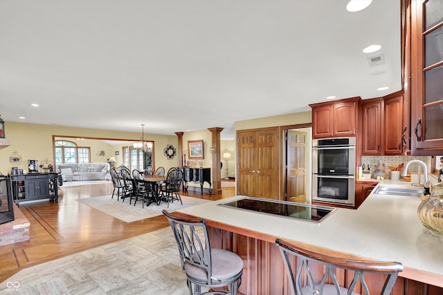 5238 N 225 E, Whiteland, IN 46184 - kitchen with double oven, black electric cooktop, a kitchen breakfast bar, a peninsula, and light countertops