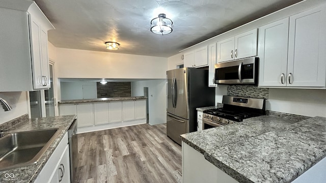 7231 S Franklin Rd, Indianapolis, IN 46259 - kitchen featuring stainless steel appliances, light wood-style flooring, a peninsula, and white cabinetry