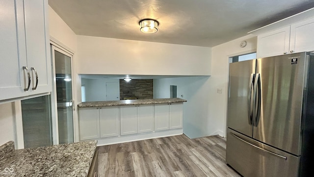 7231 S Franklin Rd, Indianapolis, IN 46259 - kitchen featuring freestanding refrigerator, white cabinetry, wood finished floors, and stone counters