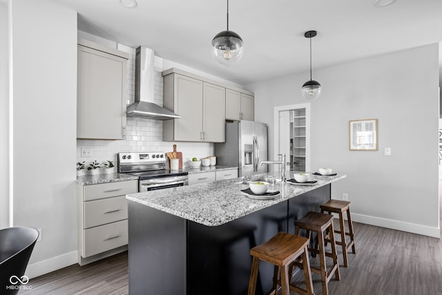 1935 Cornell Ave, Indianapolis, IN 46202 - kitchen featuring wall chimney exhaust hood, appliances with stainless steel finishes, dark wood-type flooring, backsplash, and a kitchen island with sink